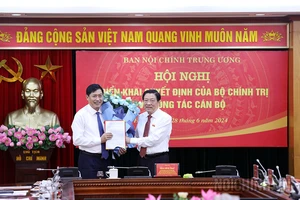 Đồng chí Phan Đình Trạc, Ủy viên Bộ Chính trị, Bí thư Trung ương Đảng, Trưởng Ban Nội chính Trung ương trao Quyết định và tặng hoa chúc mừng đồng chí Nguyễn Hữu Đông. Nguồn: VGP 