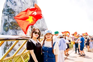 Du khách tham quan Khu du lịch Sun World Ba Na Hills (TP Đà Nẵng) được trang trí hàng trăm lá cờ Tổ quốc. Ảnh: XUÂN QUỲNH