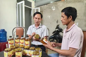 Ông Nguyễn Hồng Châu (bên phải) thuyết minh về sản phẩm mật ong do người dân sản xuất