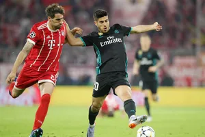 Marco Asensio (phải) vượt qua J. Martinez của Bayern Munich.