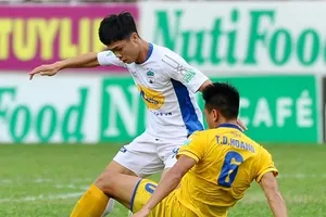 Hậu vệ SLNA cố gắng ngăn chặn pha đi bóng của Công Phượng. Ảnh: ANH TIẾN