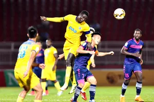 Pape Omar (20 - FLC Thanh Hóa) đánh đầu trước sự truy cản của Ngọc Duy (7 - Sài Gòn). Ảnh: NGUYỄN NHÂN