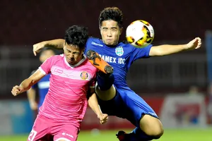 Hữu Sơn (27, CLB Sài Gòn) tranh bóng với Anh Tài của Bình Dương. Ảnh: NGUYỄN NHÂN