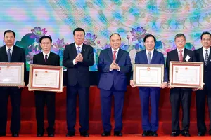 Thủ tướng Nguyễn Xuân Phúc trao tặng Huân chương Độc lập hạng Ba và Huân chương Lao động hạng Nhất cho các tập thể. Ảnh: TTXVN