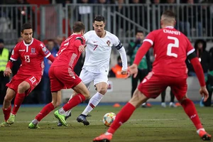 Ronaldo (áo trắng) đi bóng trước hàng phòng ngự Luxembourg