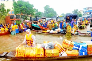 Người dân đổ về rốn lũ huyện Lệ Thủy, tỉnh Quảng Bình, để cứu trợ đồng bào bị ngập lụt. Ảnh: NGỌC OAI