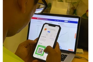 Người dân tìm hiểu ứng dụng PC-Covid. Ảnh: HOÀNG HÙNG