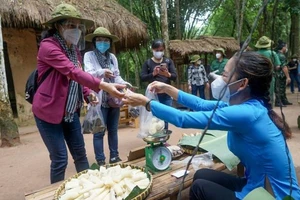 Du khách trải nghiệm tham quan, mua hàng tại Khu di tích lịch sử Địa đạo Củ Chi. Ảnh: HOÀNG HÙNG