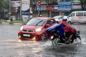 Mưa lớn, triều cường làm ngập đường, gây khó khăn cho sinh hoạt của người dân