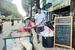 Một tuần 3 lần, quán kê chiếc bàn nhỏ phía trước, bày những túi nhỏ, mỗi túi có chai nước suối ướp lạnh, ổ bánh mì thịt