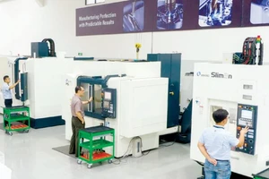 Công nhân một công ty tại TPHCM giám sát quy trình tự động sản xuất qua thông số trên màn hình máy tính. Ảnh: HOÀNG HÙNG
