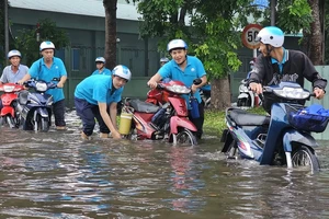 Nhiều công nhân lội nước đi làm tại Khu công nghiệp Giao Long. Ảnh: TTXVN