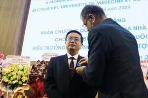 Ông Olivier Brochet, Đại sứ Cộng hòa Pháp tại Việt Nam, thay mặt Tổng thống Cộng hòa Pháp trao Huân chương Công trạng Quốc gia, tước hiệu Hiệp sĩ cho GS-TS Nguyễn Vũ Quốc Huy. Ảnh: TTXVN