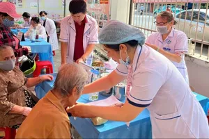 Nhân viên y tế đang lấy máu kiểm tra sức khỏe cho người cao tuổi phường Phú Lâm, TPHCM