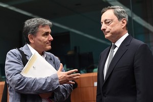 Greece’s Finance Minister Euclid Tsakalotos (left) speaks with European Central Bank President Mario Draghi during a Eurogroup finance ministers meeting on Monday at the European Council in Brussels. - AFP/VNA 