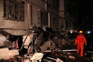 A Bangladeshi rescue worker walks through rubble and debris at a garment factory in Gazipur on Monday, after an explosion at the factory on the outskirts of Dhaka.