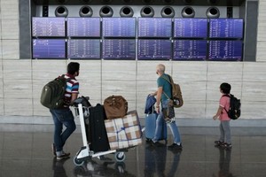 Passengers check the departures board at the Hamad International Airport in Doha on July 20, 2017. — AFP/VNA 