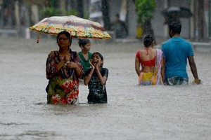 Days of intense monsoon downpours have deluged the densely-populated city of more than 20 million, paralysing crucial local train services and leaving commuters to wade through swirling waist-high waters. Photo AFP/VNS