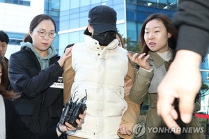 A 14-year-old girl (center) enters a court in Seoul on Oct. 30. 2017, to attend an arraignment after an arrest warrant was requested for her over the death of her middle school friend at the hands of her father. (Yonhap)