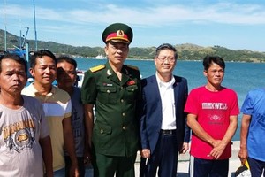Vietnamese Ambassador to the Philippines Ly Quoc Tuan (third from right) and Defence Attache Nguyen Van Hung (centre) with five fishermen who return home after a ceremony on November 29 (Photo: VNA)