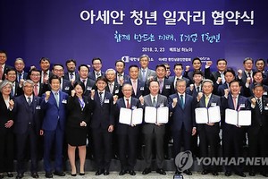 President Moon Jae-in (front row, fifth from R) poses for a group photo in a ceremony held in Hanoi on March 23, 2018 to mark the launch of a new job creation campaign by South Korean businesses in Vietnam and other member countries of the Association of 