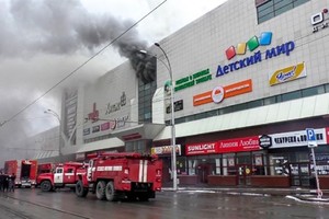 This handout picture released by the Russian Emergency Situations Ministry shows emergency vehicles as they gather outside a burning shopping centre in Kemerovo, in western Siberia. — AFP/VNA Photo