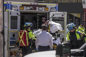 This photo released by the Associated Press shows rescue workers transporting an injured person into an ambulance in Toronto after a van mounted a sidewalk and crashed into pedestrians on April 23, 2018. (Yonhap)