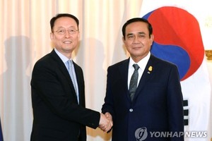 Paik Un-gyu, South Korean minister of trade, industry and energy (L), shakes hands with Thailand's Prime Minister Prayuth Chan-ocha (R) after their meeting in Bangkok on May 16, 2018, in this photo provided by the ministry. (Yonhap)