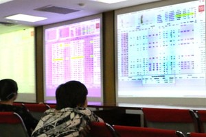 Investors follow transactions at Saigon Securities Inc (SSI) in Hà Nội. — VNS Photo Đoàn Tùng