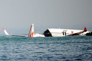 A Lion Air Boeing 737 lies submerged in the water after missing the runaway during landing at Bali’s international airport near Denpasar on April 14, 2013. Local authorities confirmed that flight JT610 departed the airport near the capital Jakarta on sche