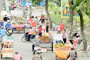 Xe hàng rong buôn bán lấn chiếm lòng đường quốc lộ 1A đoạn qua huyện Bình Chánh. Ảnh: THÀNH TRÍ