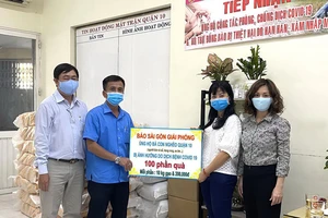 Đại diện Báo SGGP chuyển Ủy ban MTTQ quận 10 số tiền và quà giúp người bán vé số. Ảnh: NGỌC NGÂN