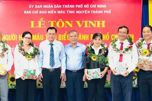 Phó Trưởng ban Dân vận Thành ủy TP Nguyễn Văn Lưu và Chủ tịch Hội Chữ thập đỏ TP Trần Trường Sơn tặng hoa chúc mừng các cá nhân điển hình hiến máu tình nguyện. Ảnh: Thanhuytphcm.vn