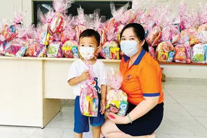 Các bé nhận quà được đeo khẩu trang, sát khuẩn kỹ càng