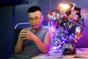 Nguyễn Tuấn Anh bên chiếc đồng hồ do anh chế tác