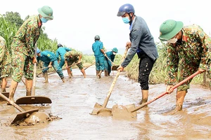 Các chiến sĩ bộ đội cùng lực lượng dân quân xung kích huyện Sơn Hòa (tỉnh Phú Yên) khắc phục bùn lũ, nhà cửa thiệt hại giúp người dân sớm ổn định cuộc sống. Ảnh: MINH CHÂU