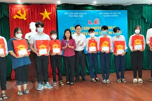Trao tiền hỗ trợ cho các em học sinh mồ côi cha hoặc mẹ do ảnh hưởng dịch Covid-19. Ảnh: BDK.VN