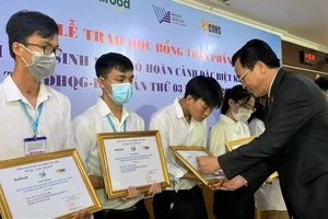 PGS-TS Nguyễn Đình Tứ, Giám đốc Quỹ Phát triển ĐH Quốc gia TPHCM, trao học bổng cho sinh viên đặc biệt khó khăn, học giỏi