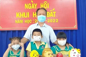 Thầy Nguyễn Phúc Hiếu và học sinh Trường Mầm non An Phú trong Ngày hội Khui heo đất