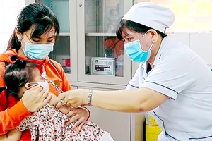 Nhân viên y tế tiêm vaccine cho trẻ em