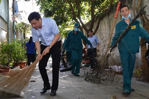 Lãnh đạo quận 7 tham gia dọn vệ sinh cùng người dân. Ảnh: VIỆT DŨNG