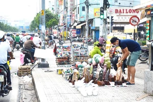 Tại dốc cầu Chợ Cầu, hàng hóa được bày bán tràn lan, gây mất an toàn giao thông