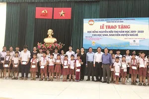 Ông Lê Văn Công, Kiểm Soát viên Công ty TNHH Một thành viên Xổ số kiến thiết TP Hồ Chí Minh cùng với lãnh đạo UBMTTQ TP, UBMTTQ huyện Nhà Bè và đơn vị Tài trợ chụp hình lưu niệm cùng với các em học sinh, sinh viên nhận học bổng