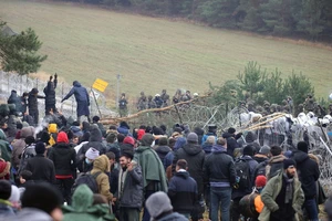 Người di cư gần hàng rào dây thép gai ở biên giới Ba Lan - Belarus. Ảnh: REUTERS