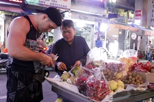 Du khách mua hàng rong tại phố đi bộ Bùi Viện, quận 1, TPHCM