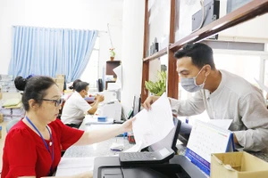 Công chức phường Bình Hưng Hòa A, quận Bình Tân, TPHCM tiếp nhận giải quyết thủ tục hành chính cho người dân. Ảnh: NGÔ BÌNH