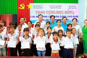 Lãnh đạo Hội Nhà báo tỉnh Trà Vinh, Agribank CN tỉnh Trà Vinh tặng học bổng cho học sinh xã Thạnh Hòa Sơn, huyện Cầu Ngang. Ảnh: CTV