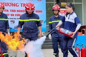 Cảnh sát PCCC TPHCM hướng dẫn người dân sử dụng dụng cụ chữa cháy. Ảnh: CHÍ THẠCH