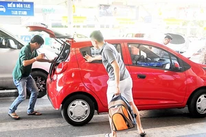 Chỉ sau 17 tháng hoạt động thí điểm, số lượng xe Grab và Uber đã gần gấp rưỡi số lượng xe mà ngành taxi Việt Nam đã có được trong suốt 30 năm. Một taxi Uber đón khách. Ảnh: THÀNH TRÍ 