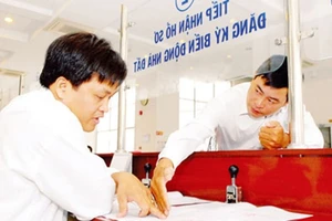 Nhân viên Văn phòng đăng ký quyền sử dụng đất Sở Tài nguyên - Môi trường TPHCM hướng dẫn người dân làm hồ sơ nhà đất